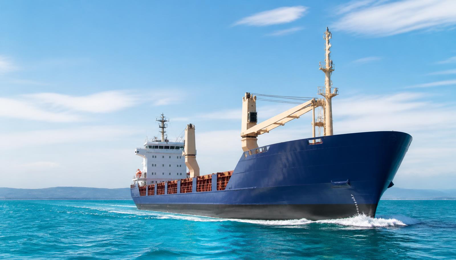 Working cargo vessel underway in clear daylight